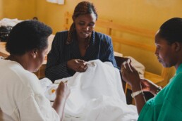 women chatting and sewing at a table together